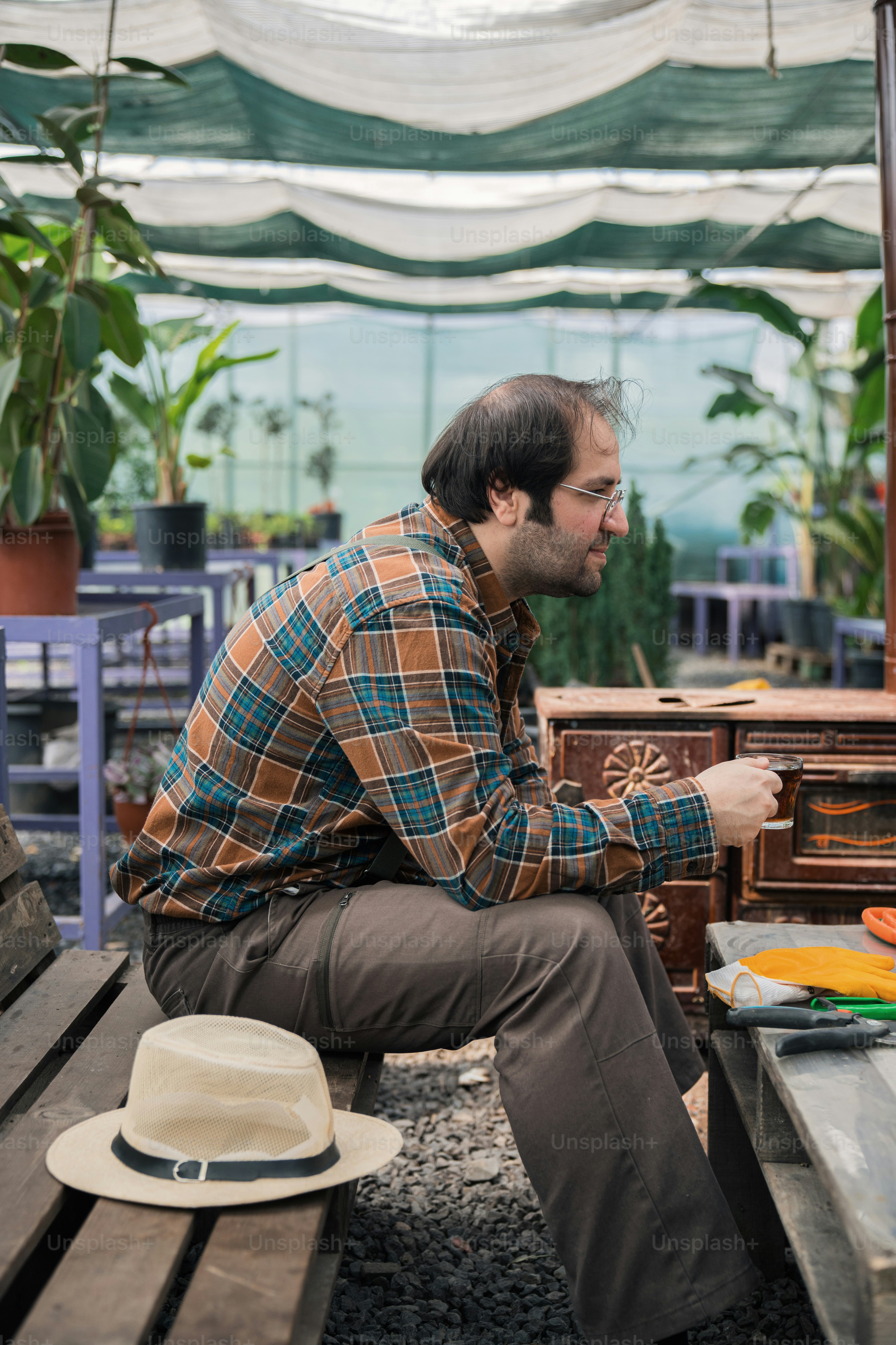 a man sitting on a bench next to a hat