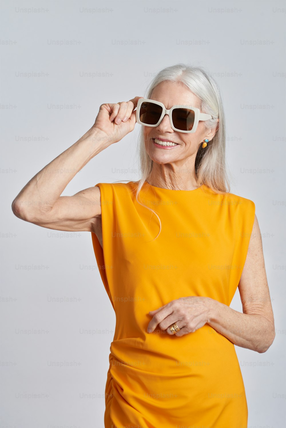 uma mulher em um vestido amarelo e óculos de sol