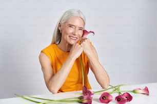 Una mujer sentada en una mesa con un ramo de flores