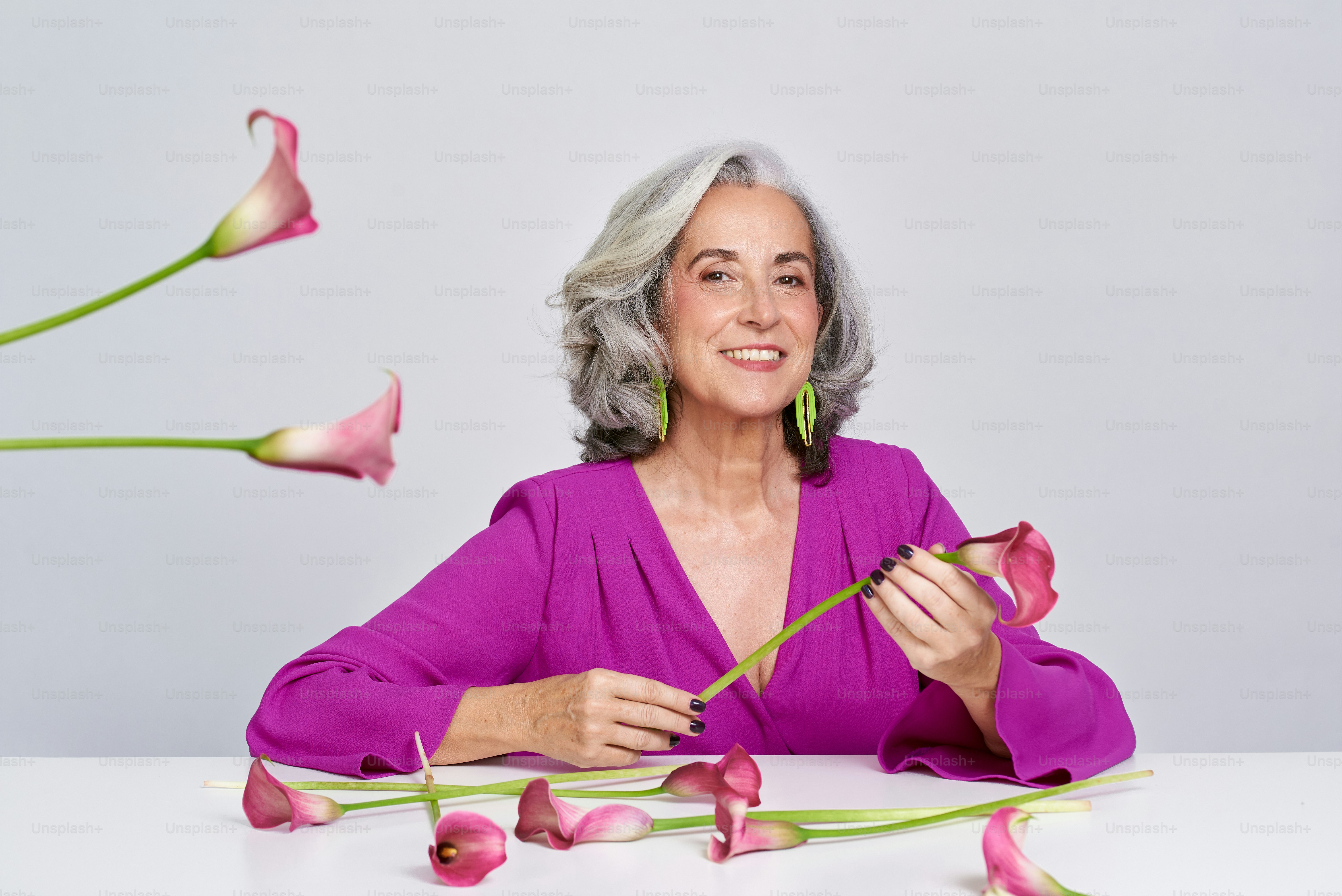 une femme assise à une table avec des fleurs devant elle