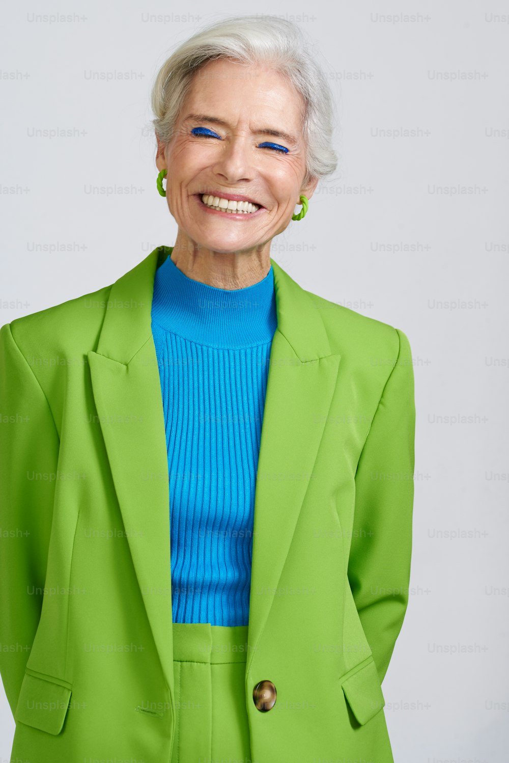 an older woman in a green suit smiling