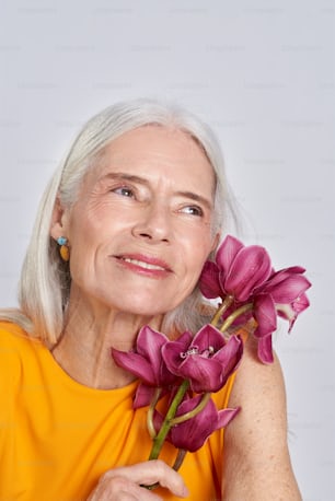 an older woman holding a bouquet of flowers