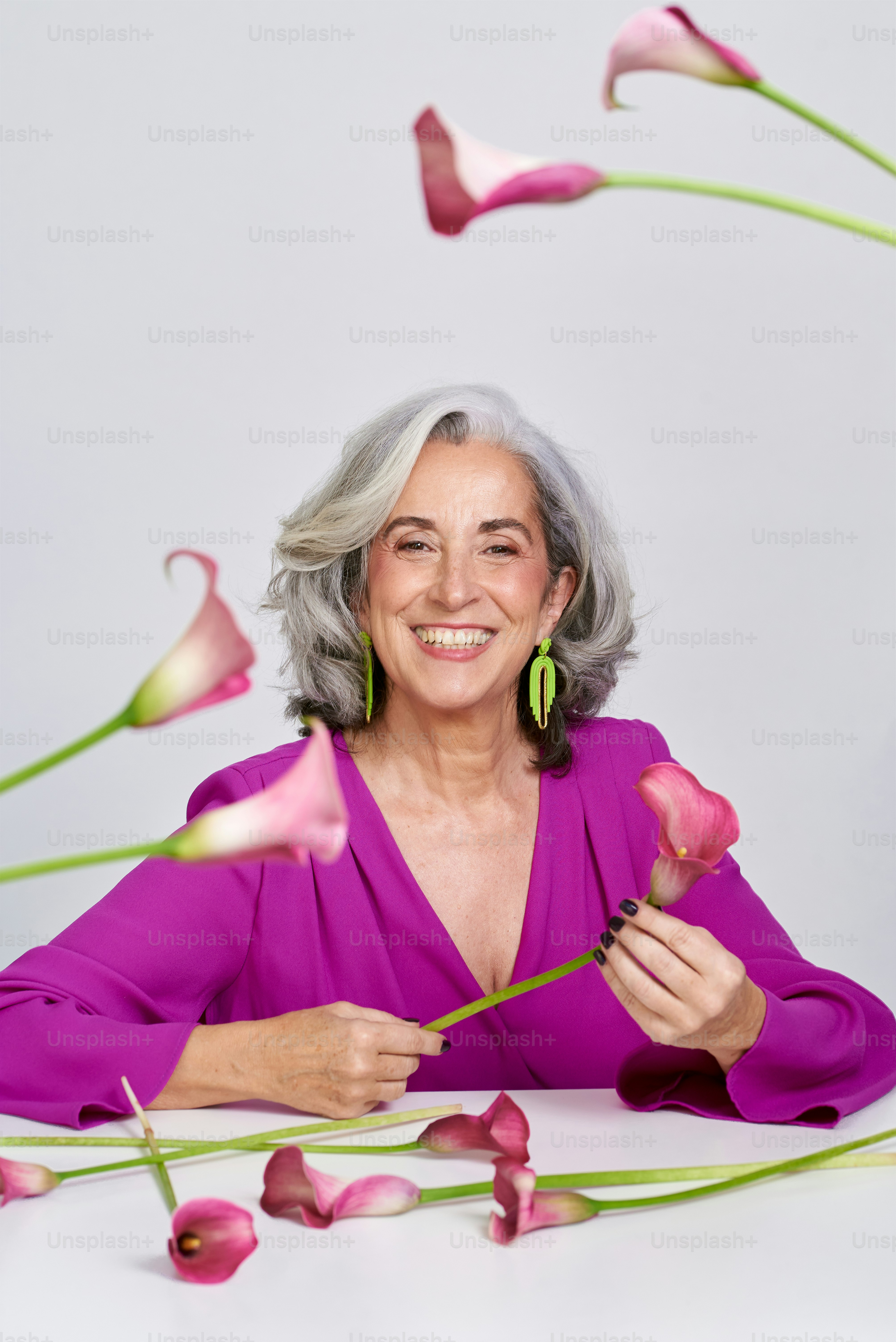 A woman sitting at a table with flowers in front of her photo – Woman ...