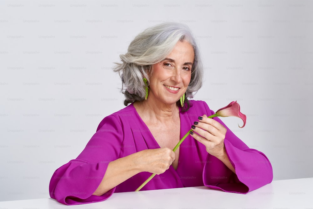 a woman in a purple shirt holding a flower