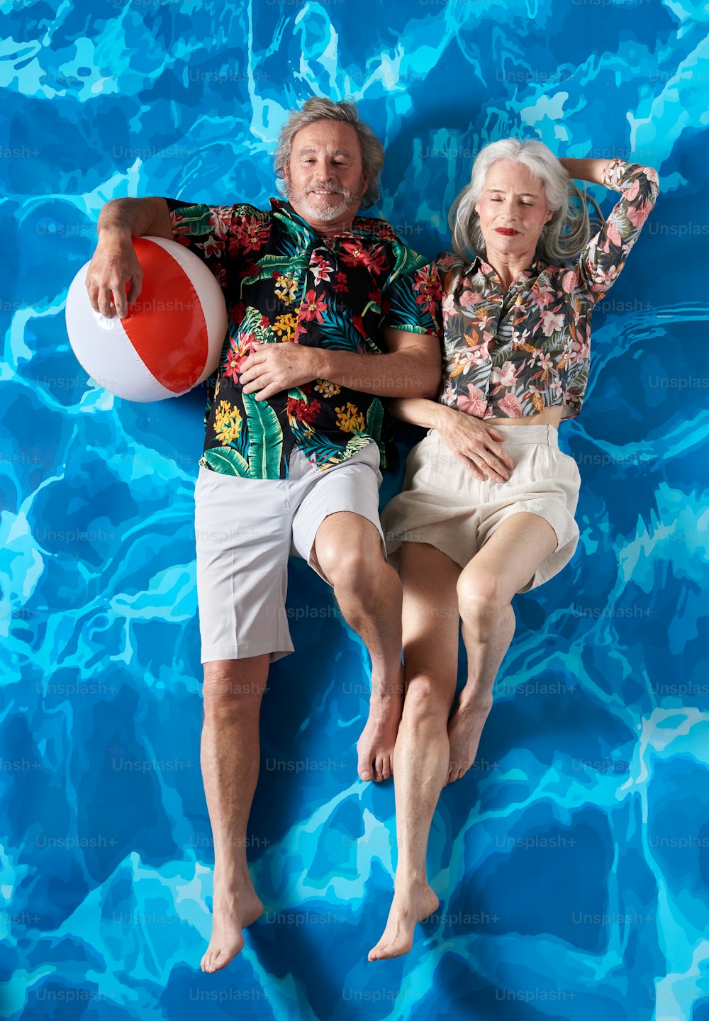 a man and a woman laying on a blue surface