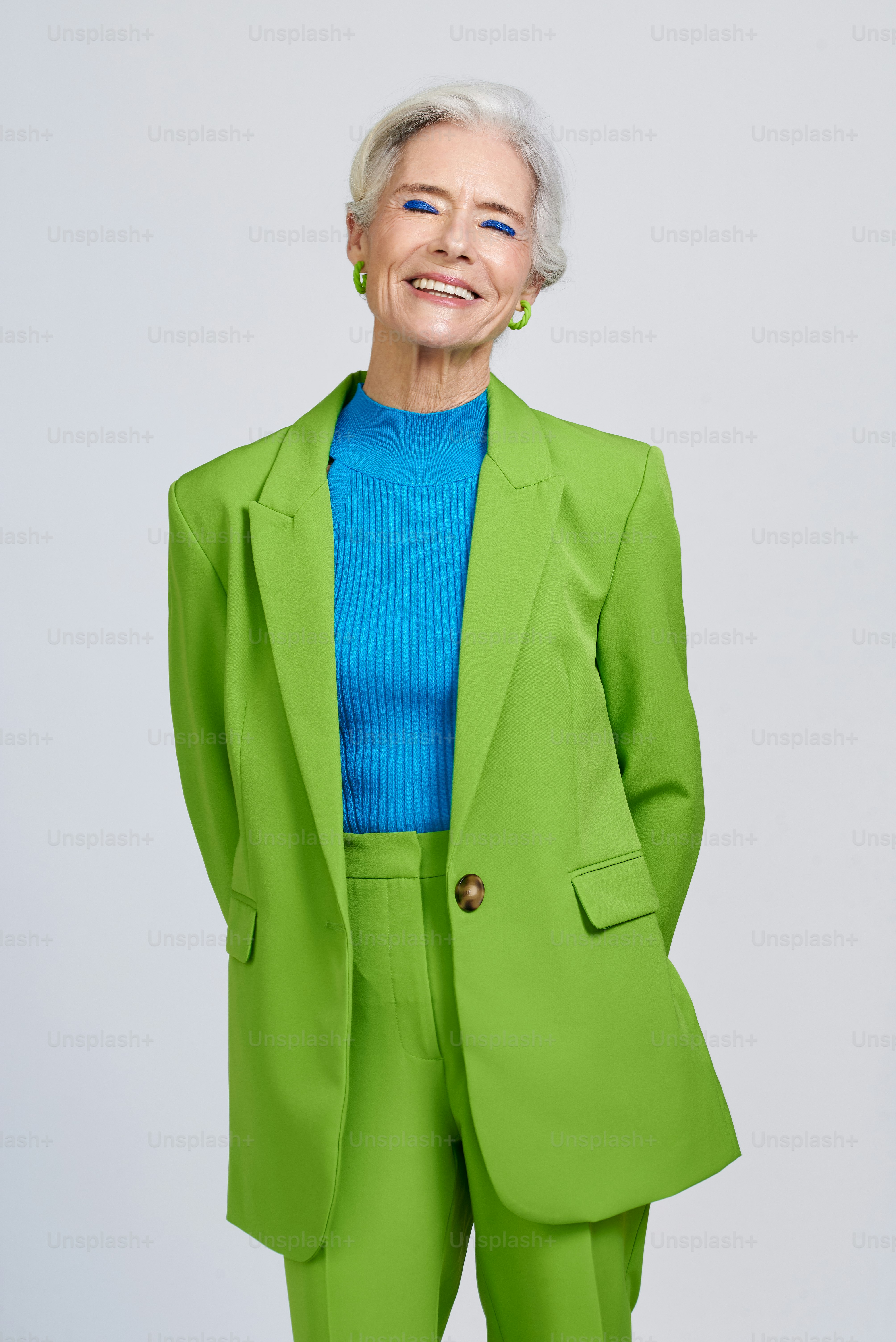 Une femme en costume vert et chemise bleue