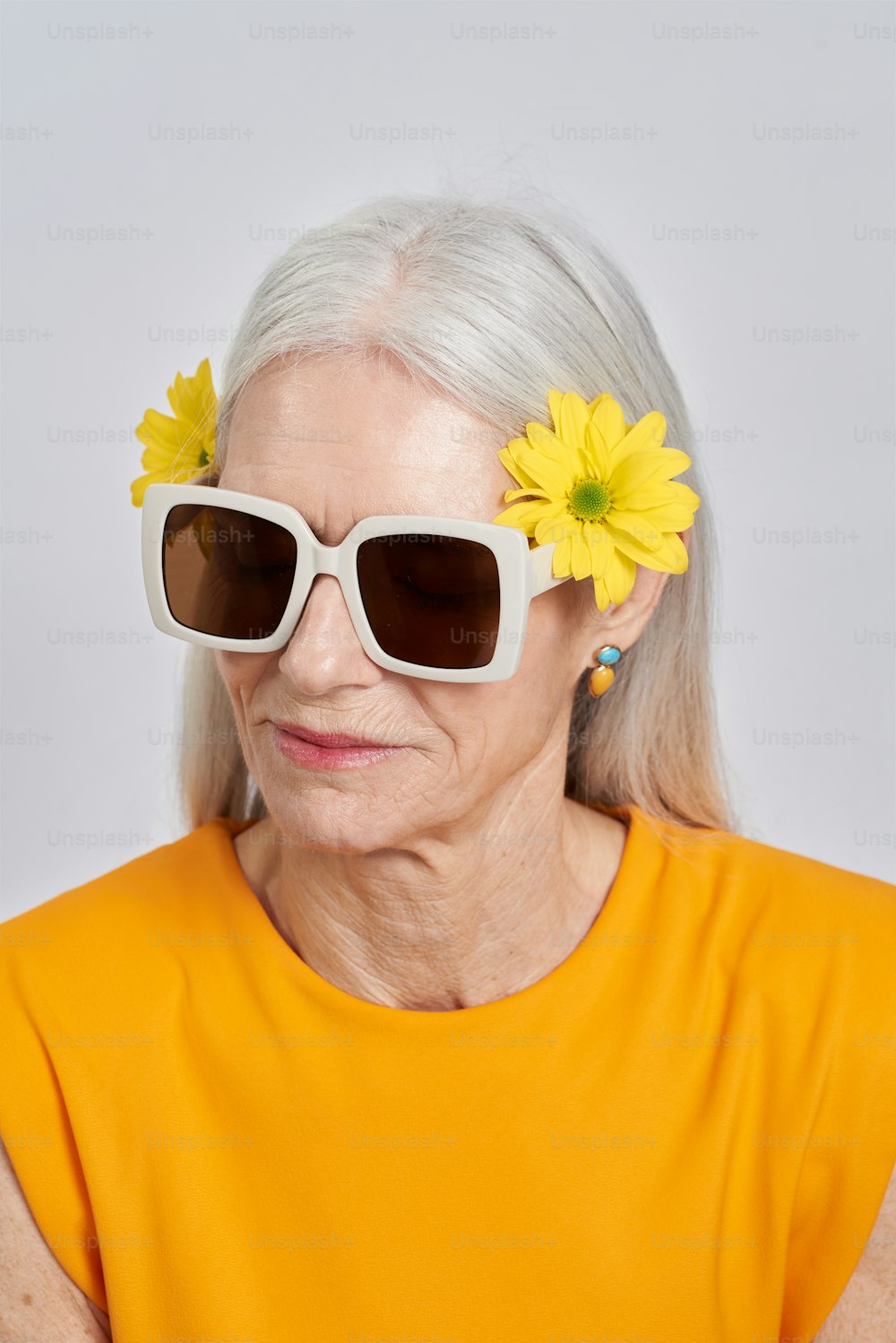 선글라스를 쓰고 머리에 꽃을 꽂은 나이��든 여자