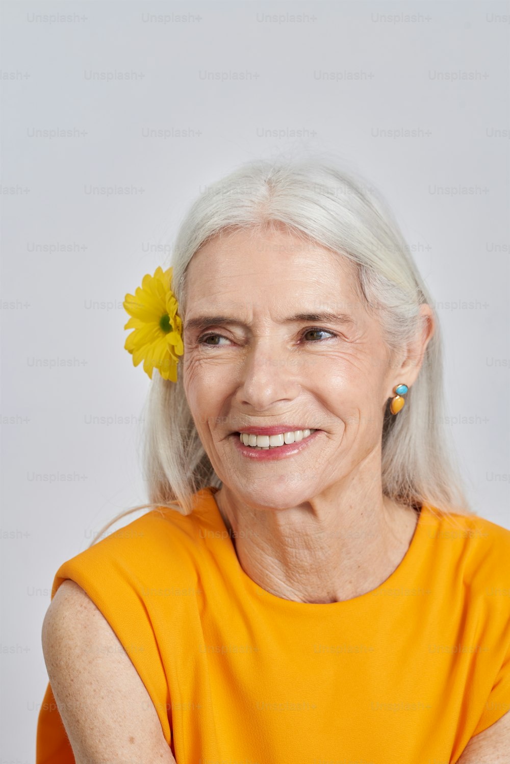 uma mulher com uma flor amarela em seu cabelo
