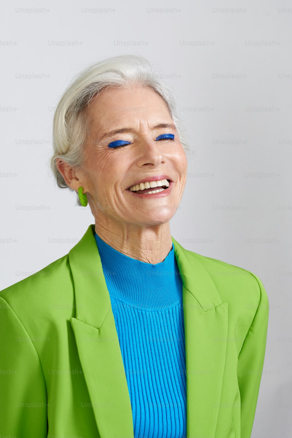 Eine Frau mit weißem Haar und blauen Augen lächelt