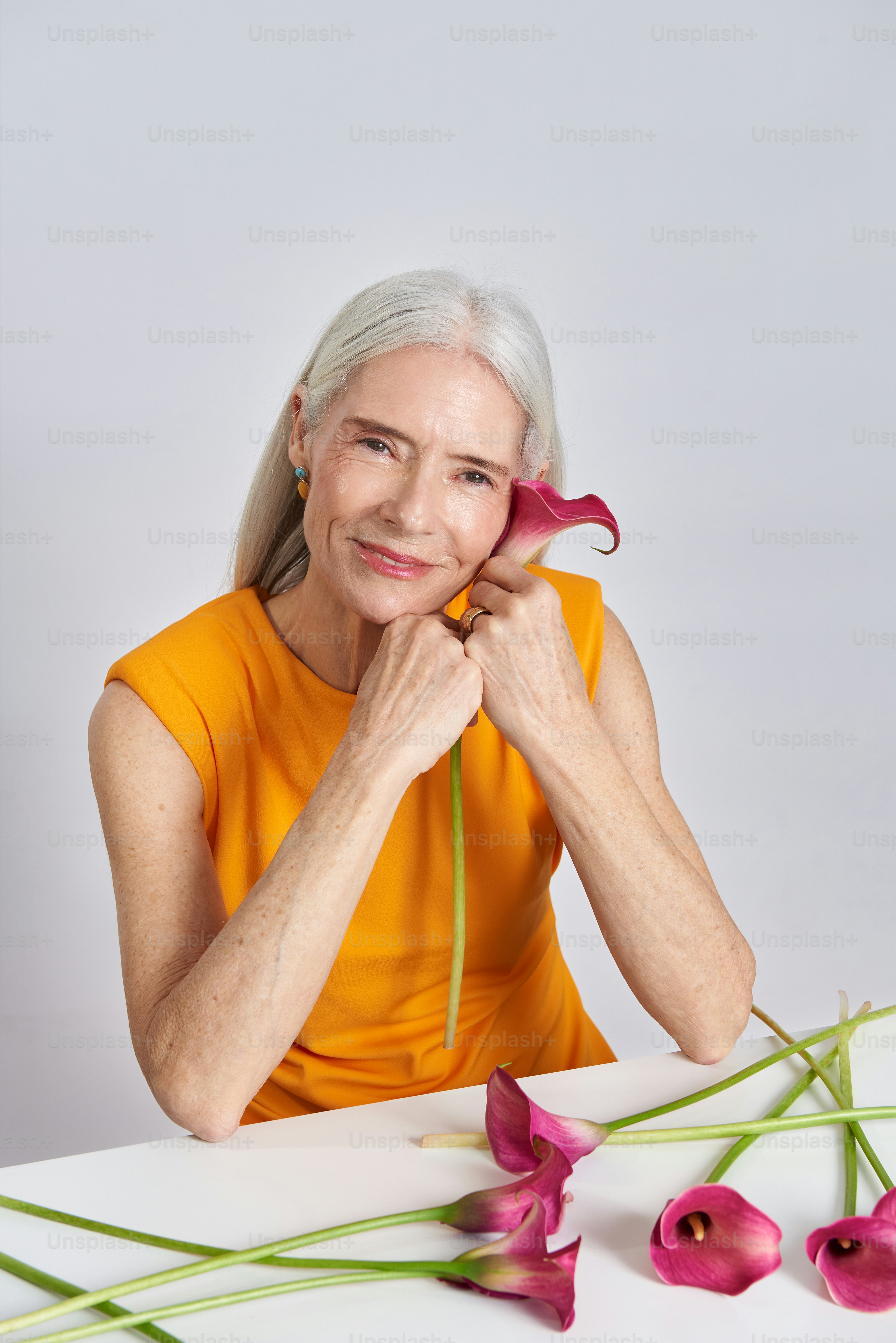 a woman sitting at a table with flowers in front of her