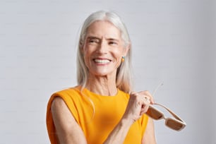eine ältere Frau mit einer Schere in der Hand
