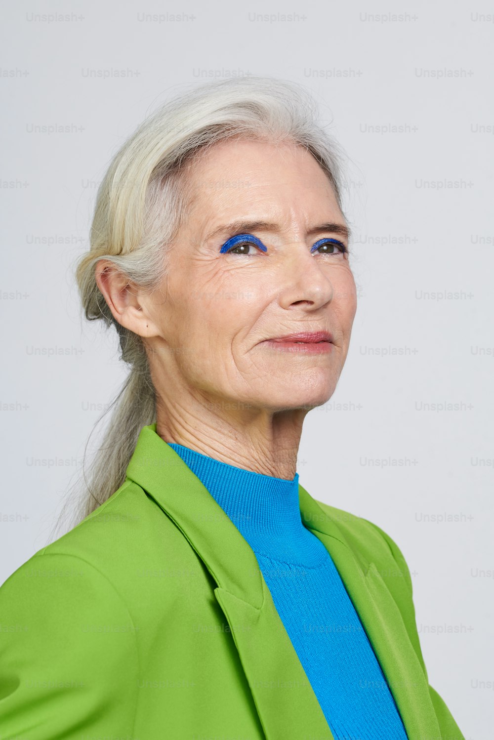 a woman with blue eyes and a green jacket