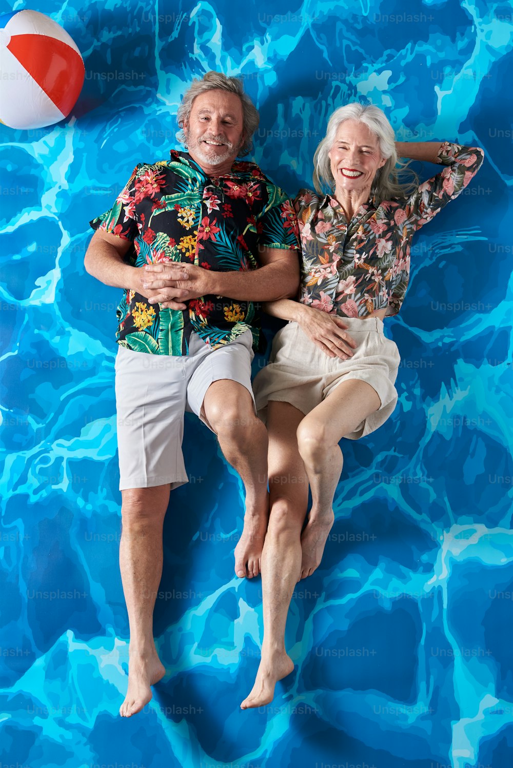un homme et une femme allongés sur une surface bleue