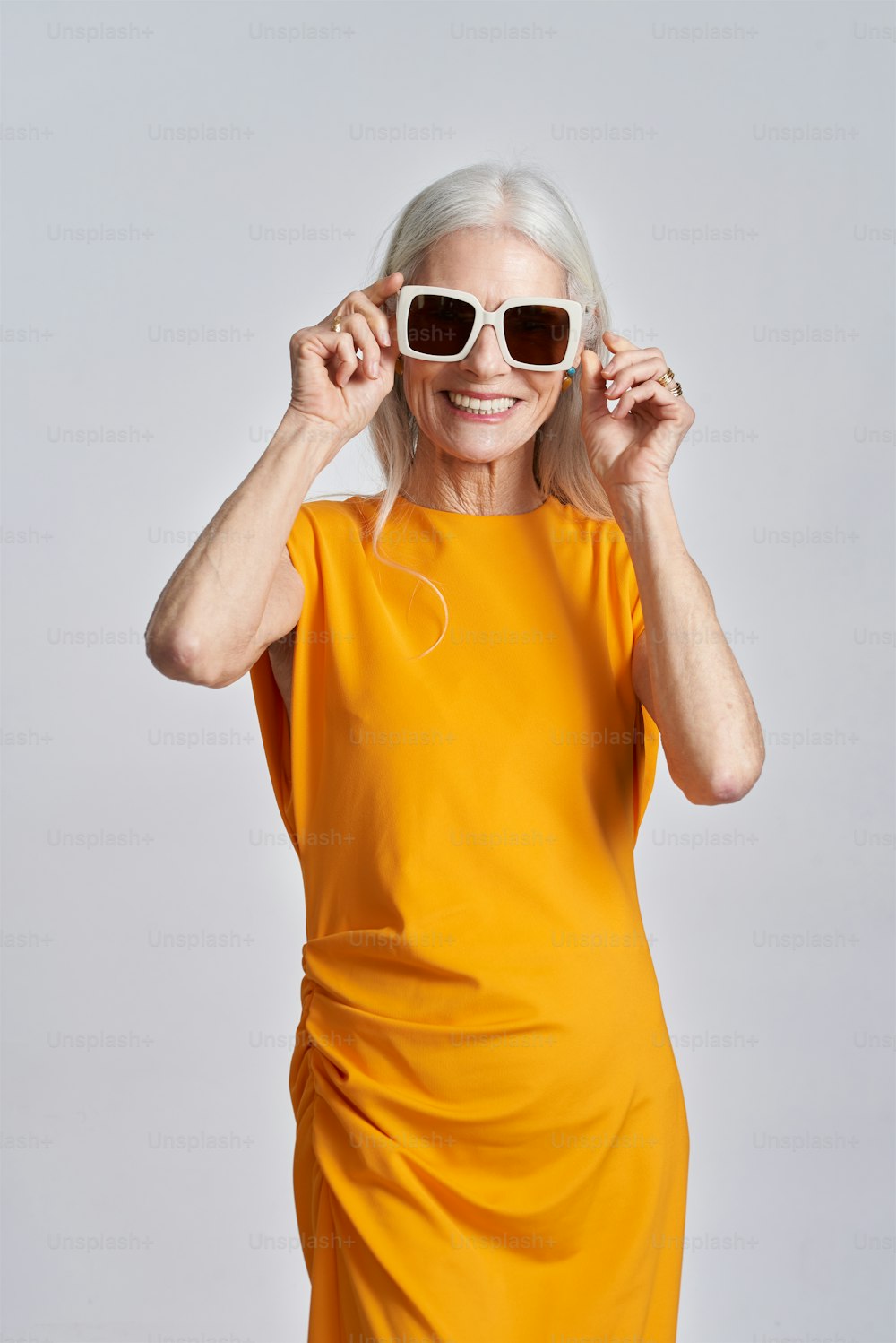 eine Frau in gelbem Kleid und Sonnenbrille
