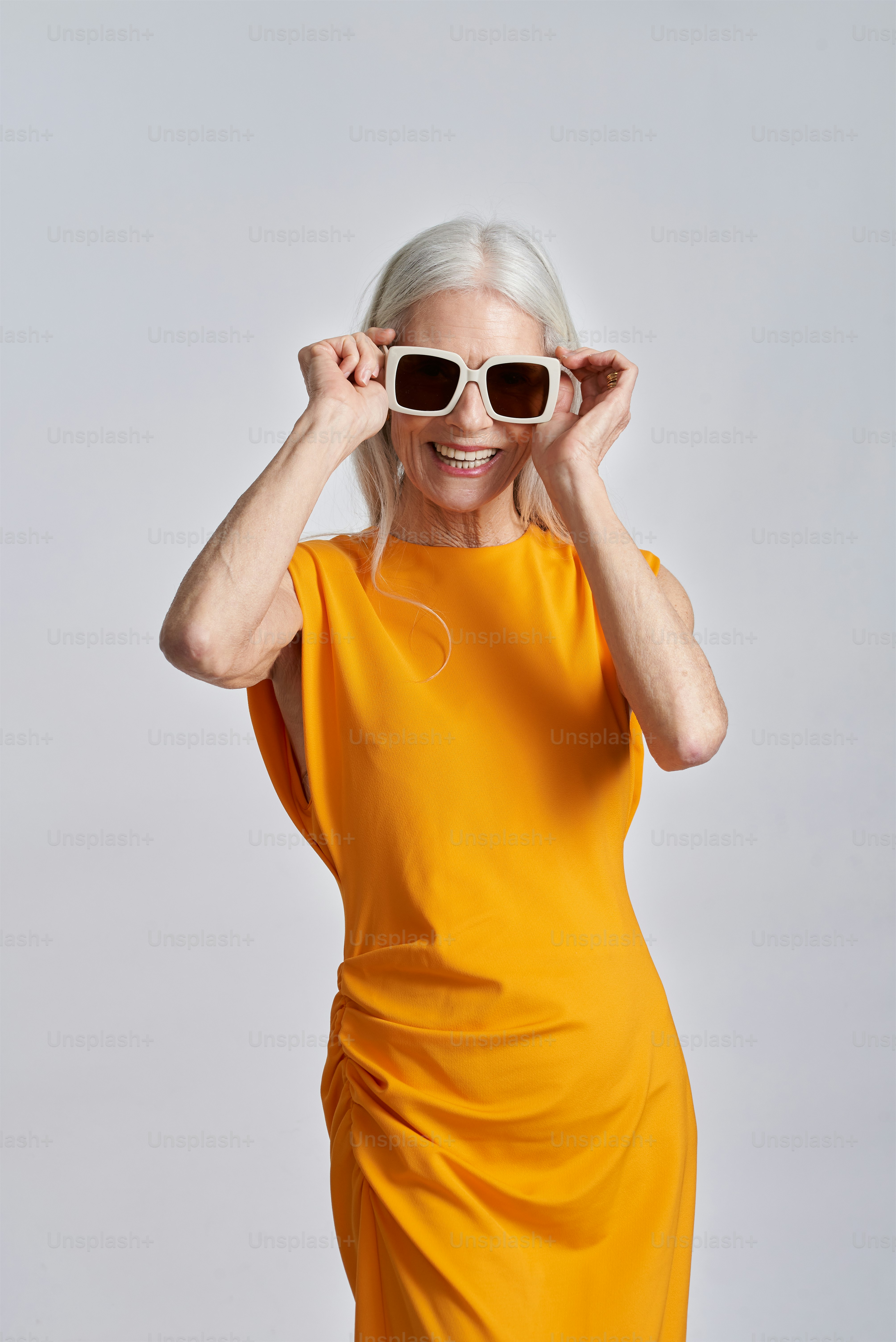 A woman in a yellow dress and sunglasses photo – Older woman Image on ...