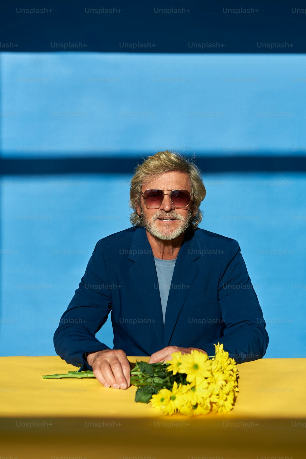 a man sitting at a table with a bunch of flowers