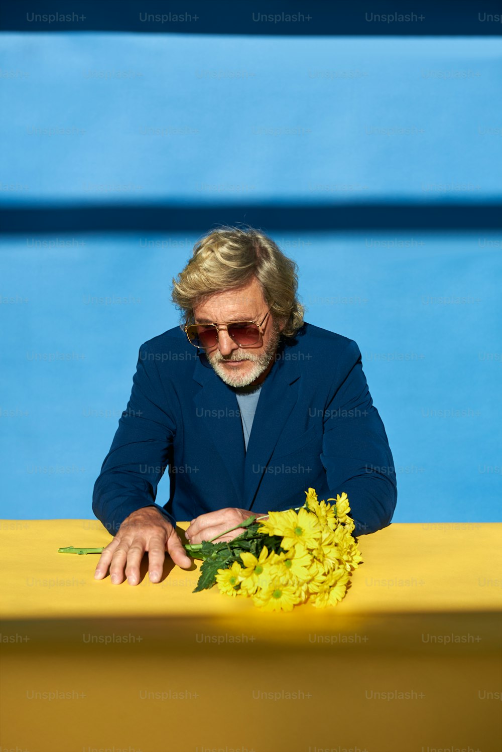 a man sitting at a table with a bunch of flowers