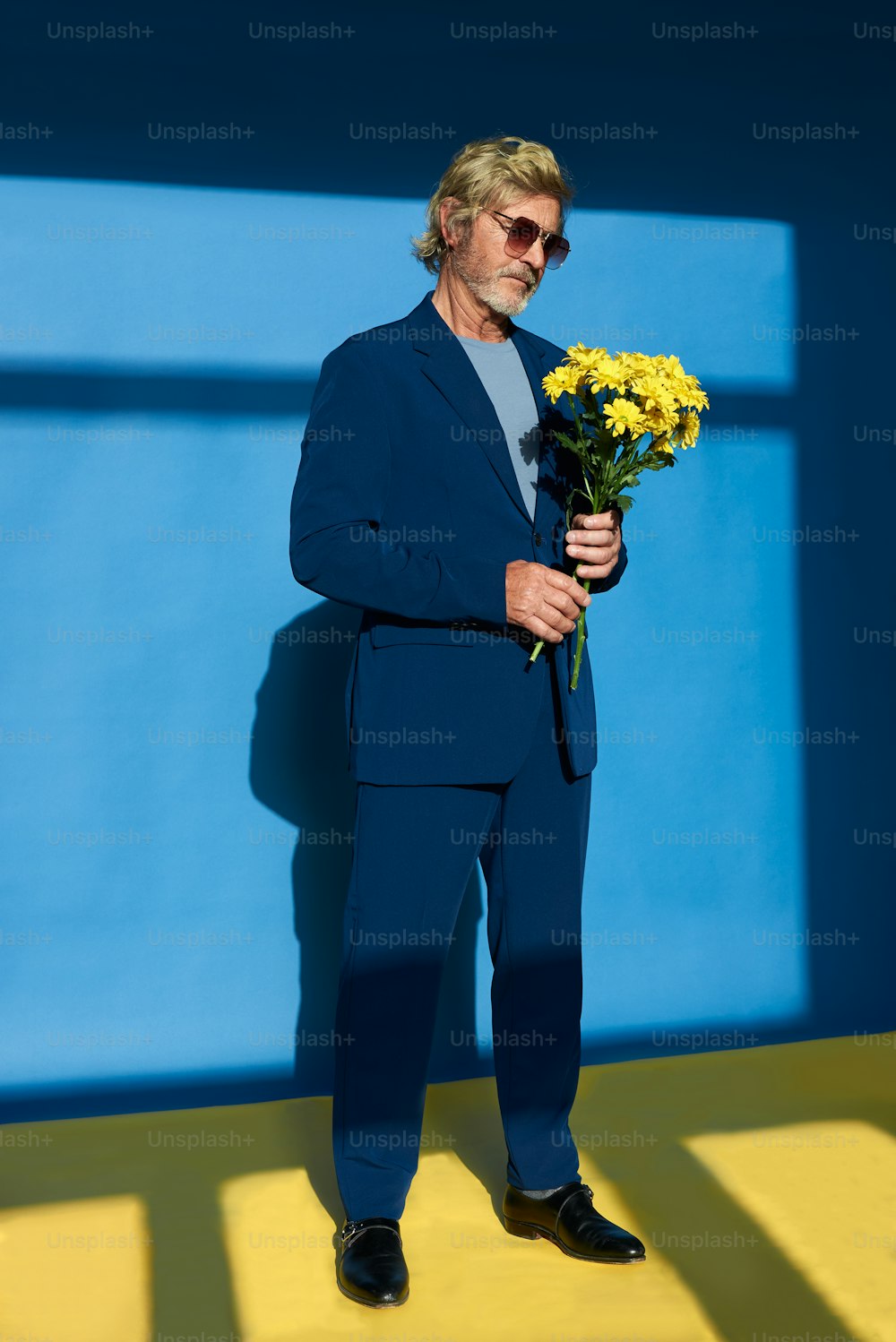 a man in a suit holding a bunch of flowers