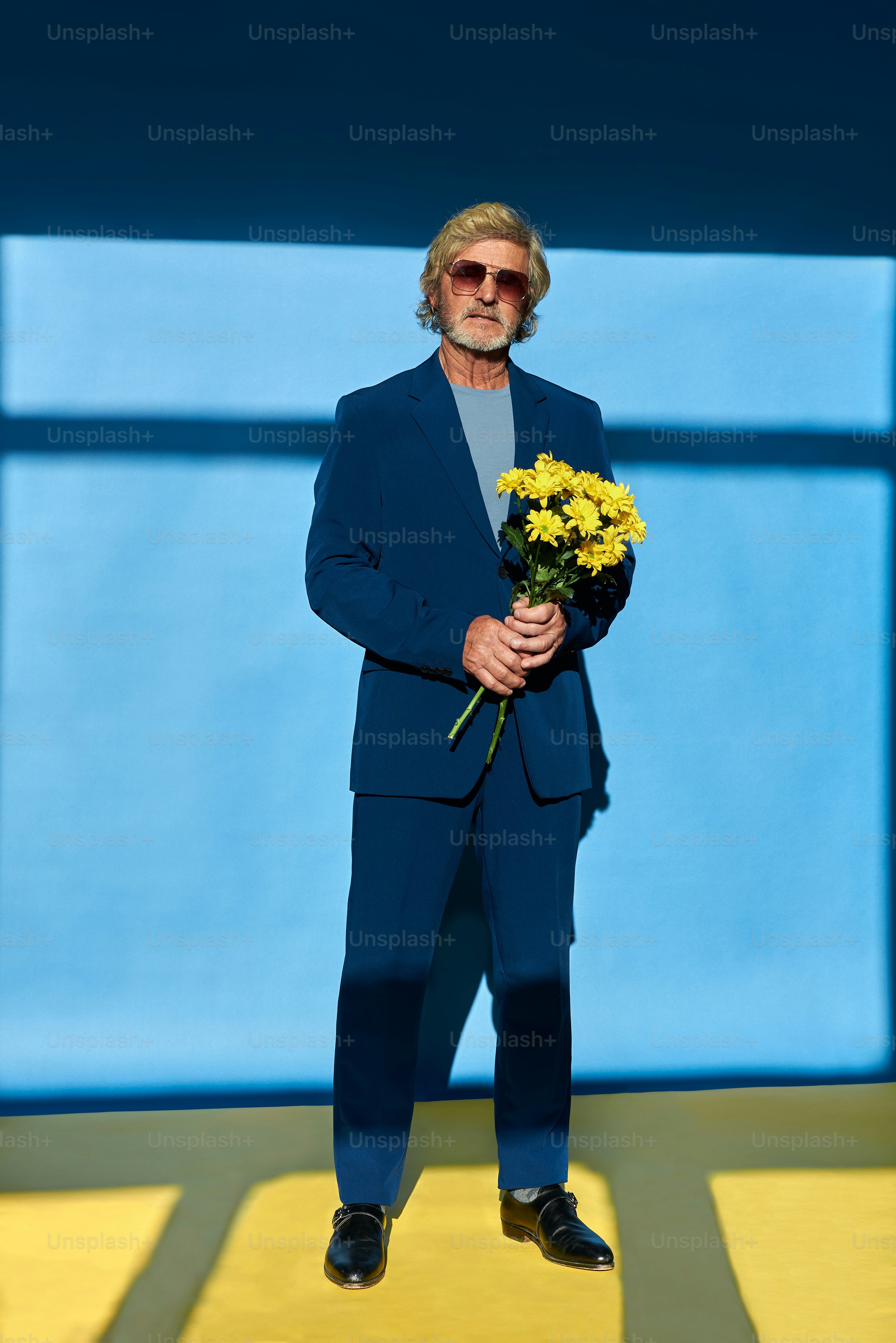 Ein Mann im Anzug, der einen Blumenstrauß hält