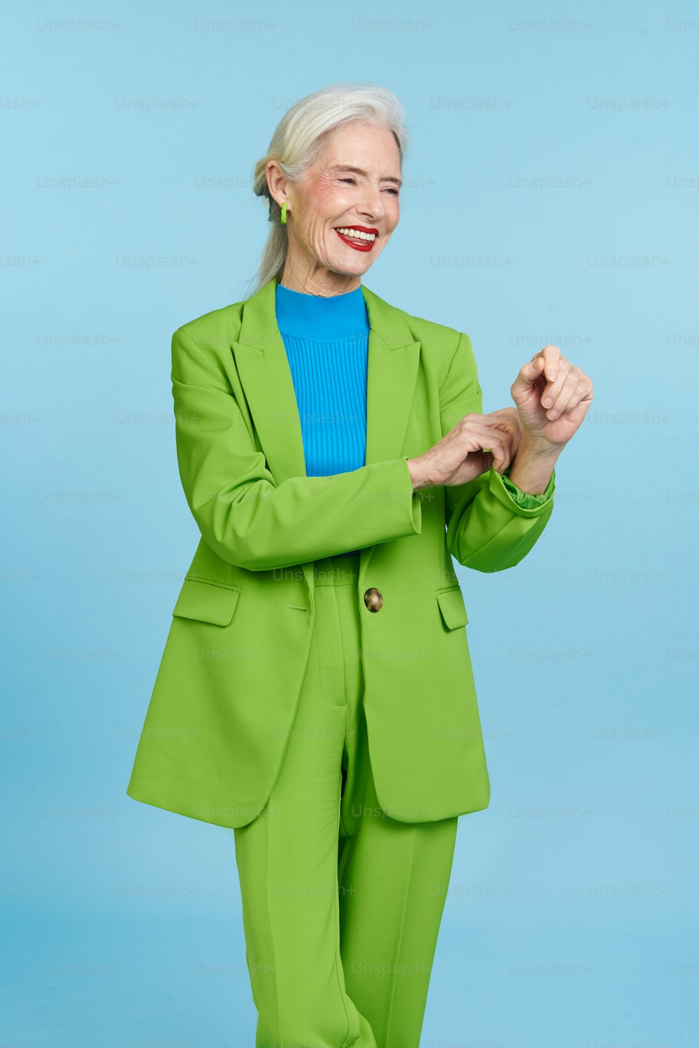 Une femme en costume vert et chemise bleue