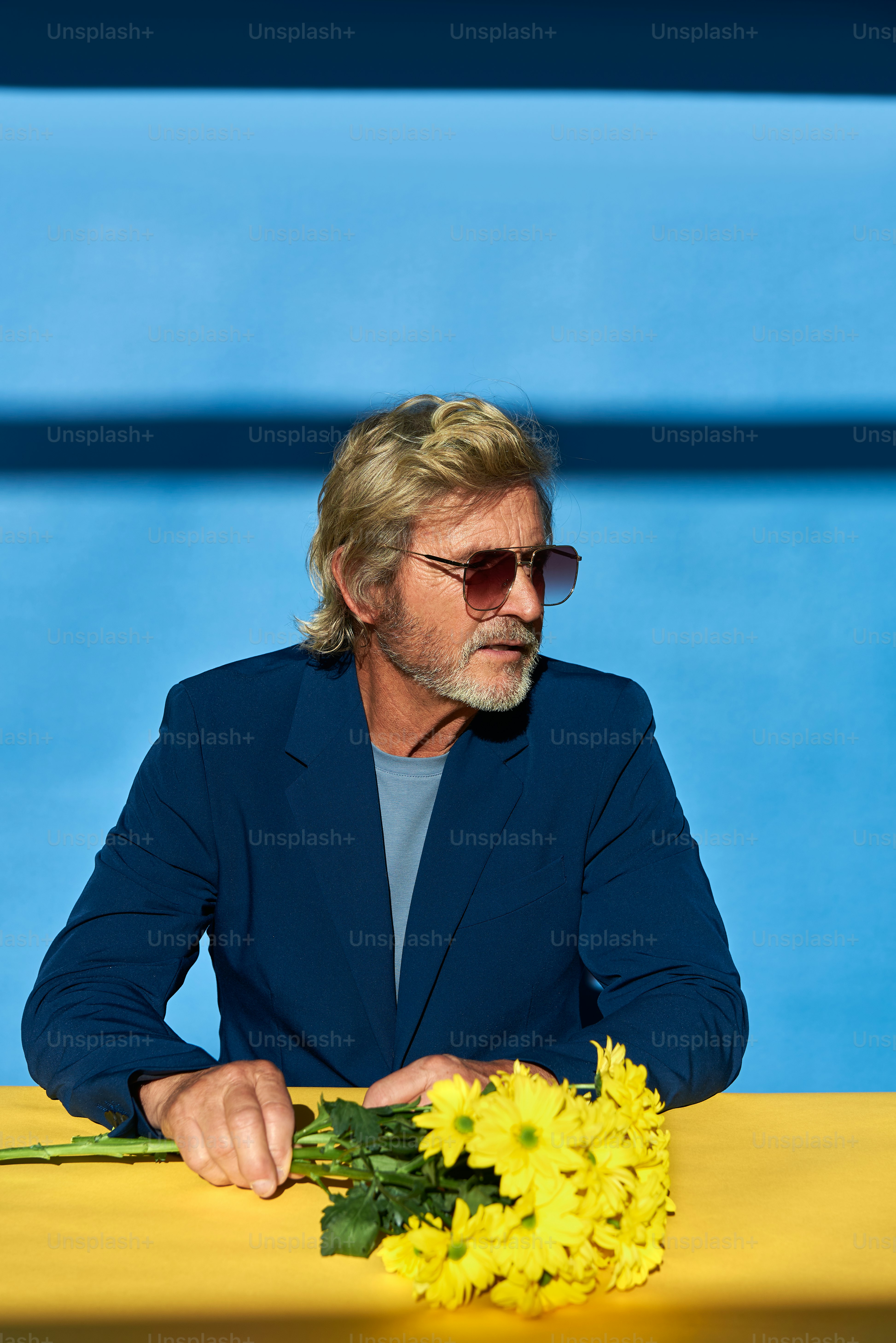 a man sitting at a table with a bunch of flowers