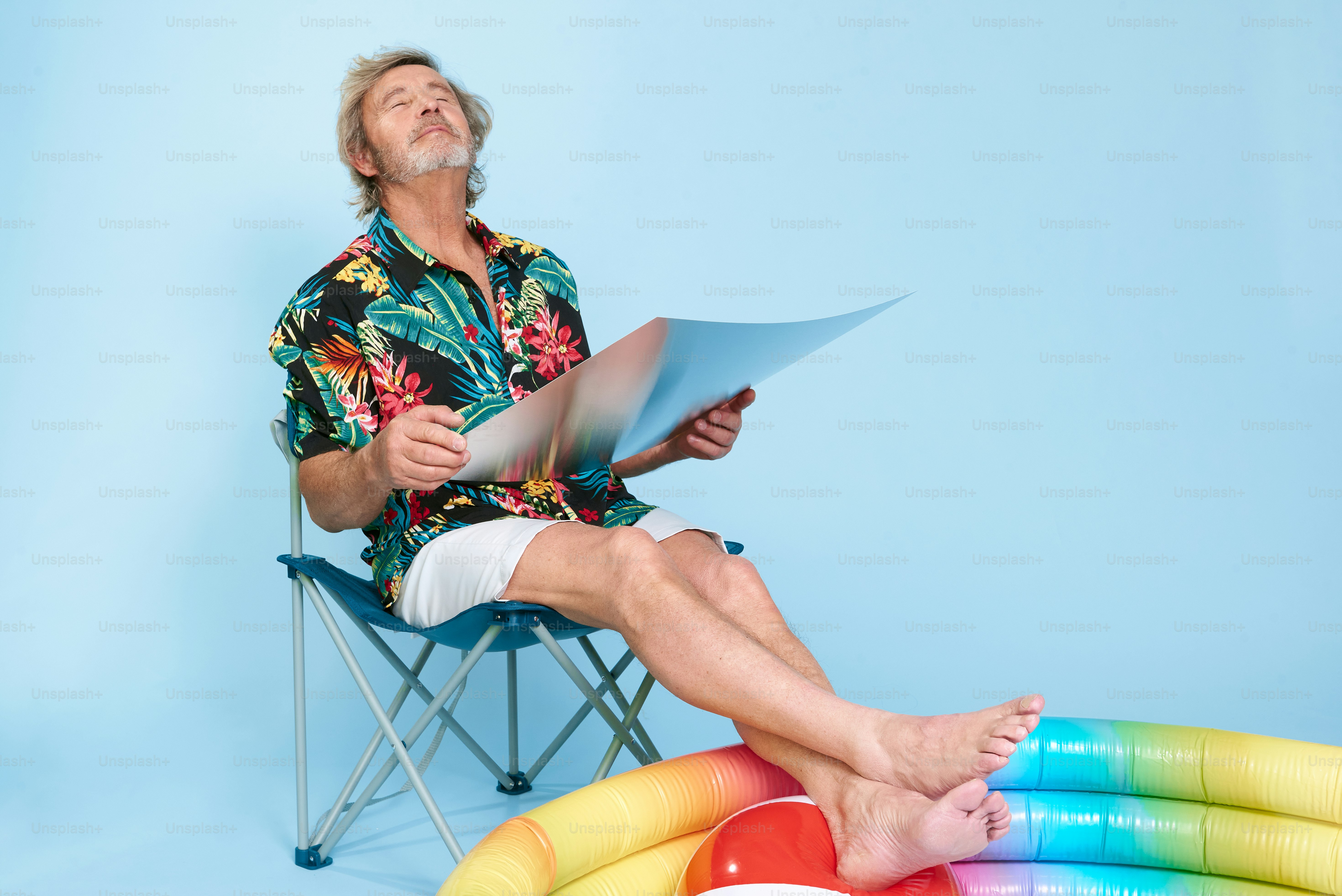 a man sitting in a chair reading a paper