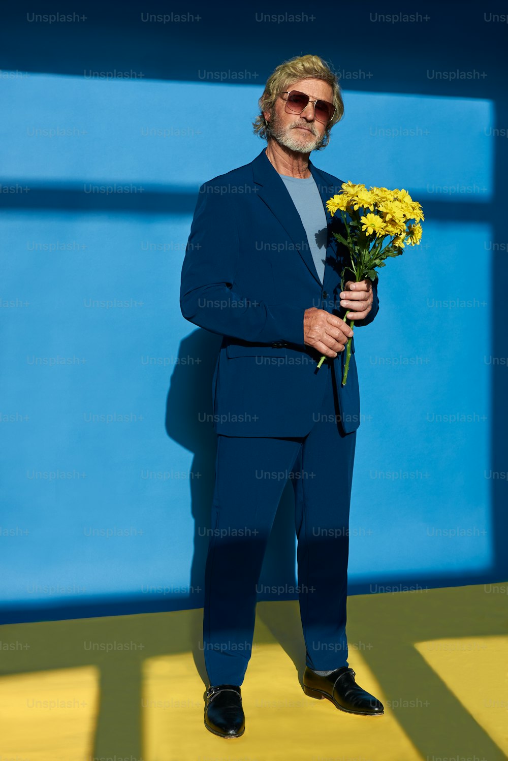 Ein Mann im Anzug, der einen Blumenstrauß hält
