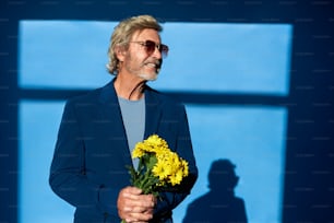 a man holding a bouquet of yellow flowers