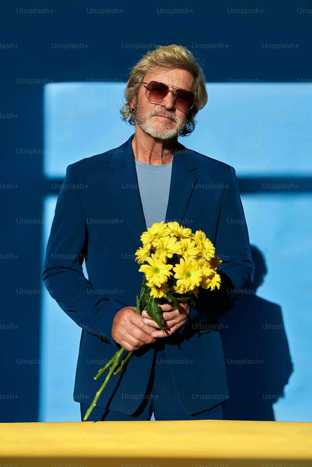 Un uomo in giacca e cravatta che tiene un mazzo di fiori
