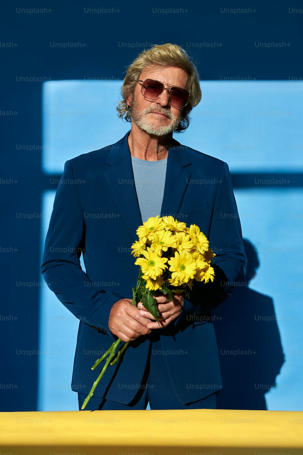 a man in a suit holding a bouquet of flowers