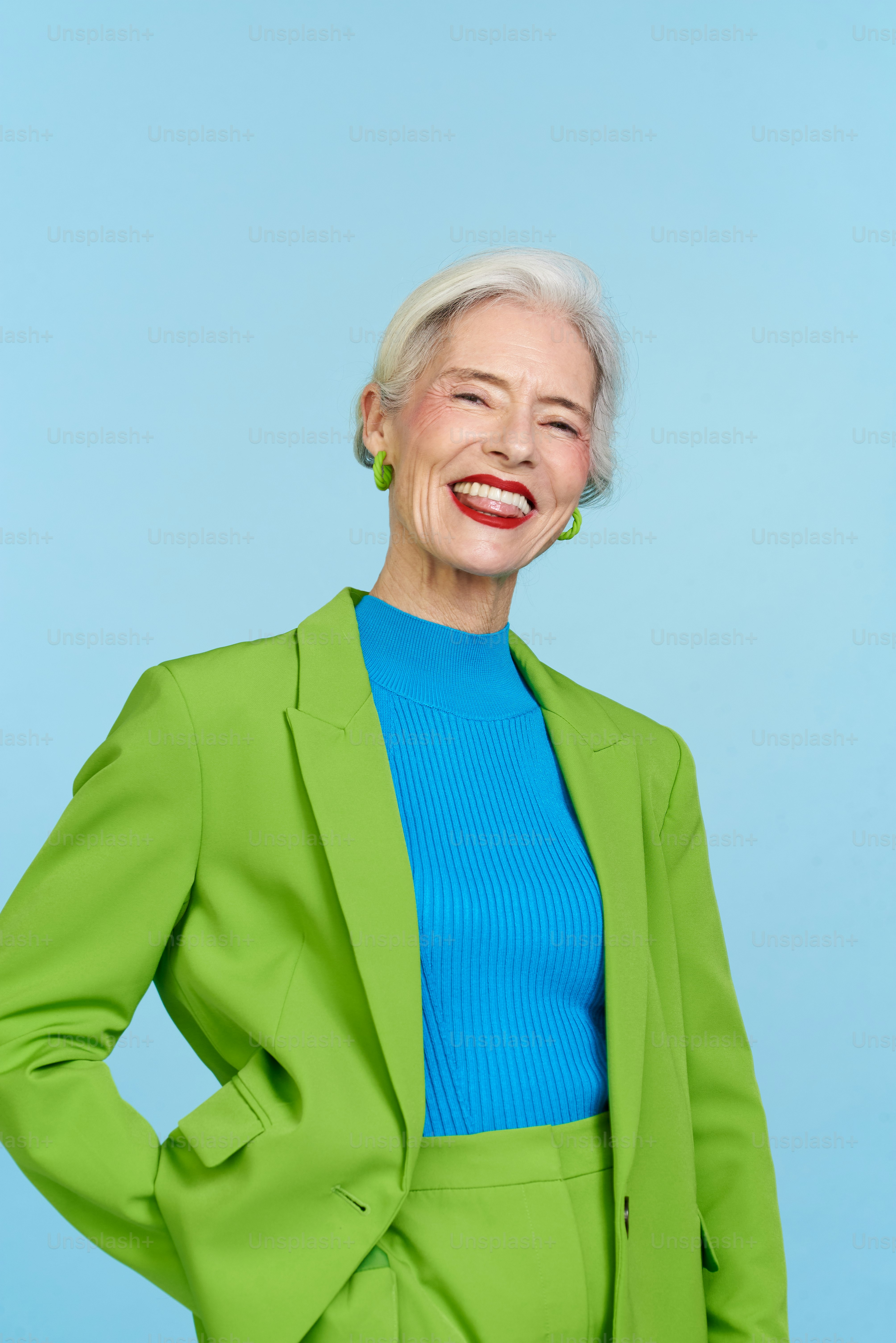 an older woman in a green suit smiling