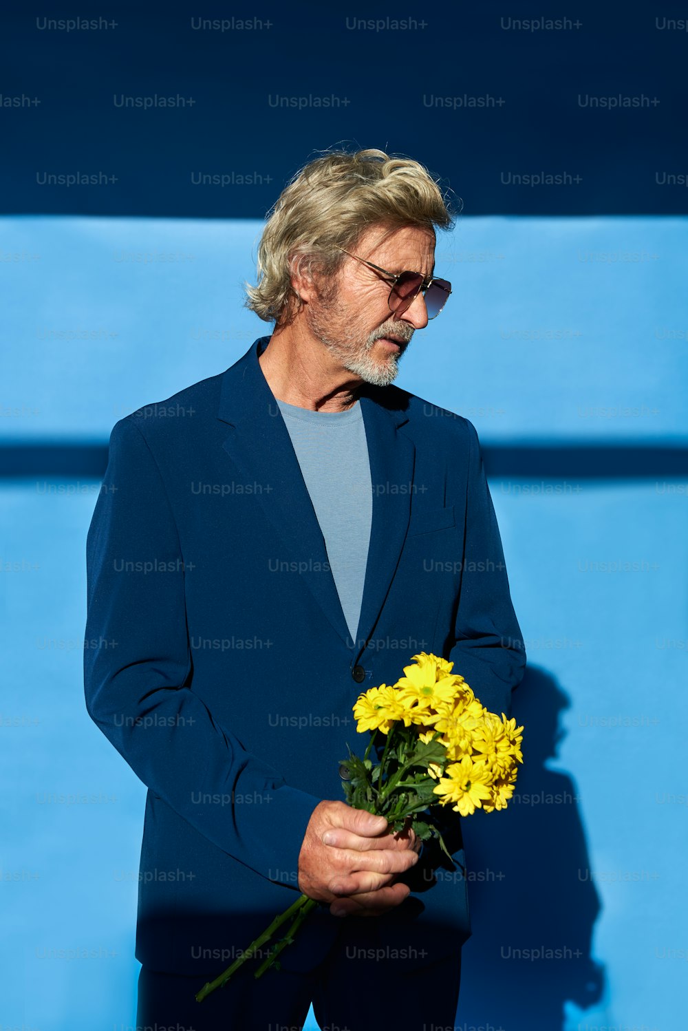 a man in a suit holding a bouquet of flowers