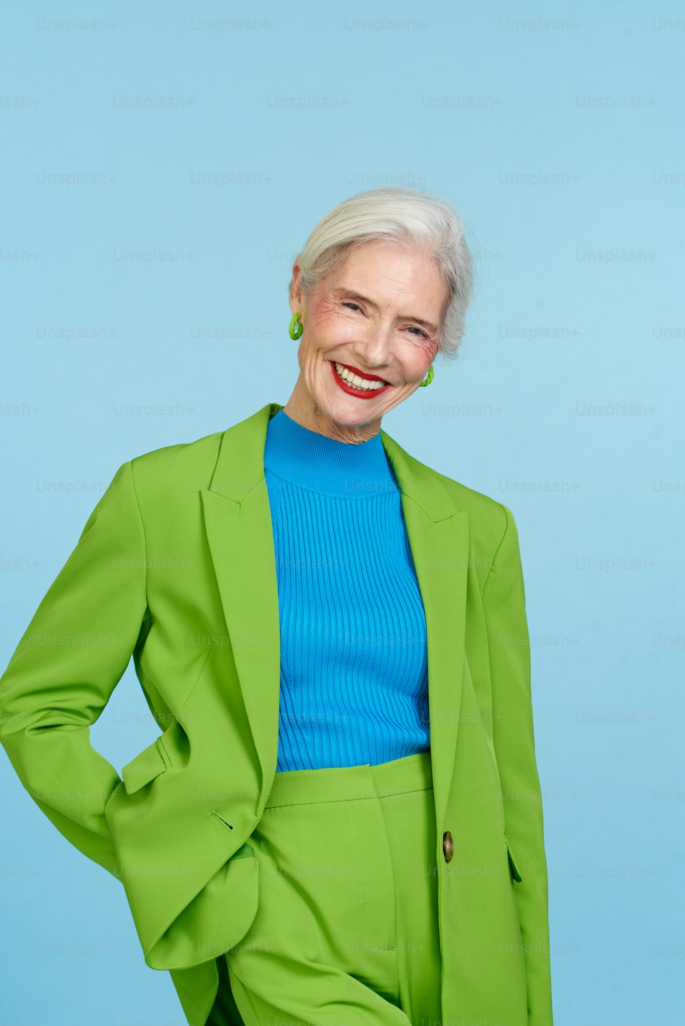 Eine Frau in grünem Anzug und blauem Oberteil