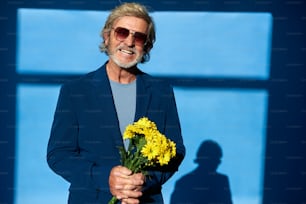 a man holding a bouquet of yellow flowers