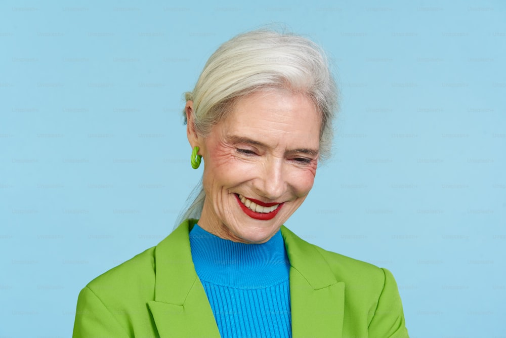 a woman with white hair and a green jacket