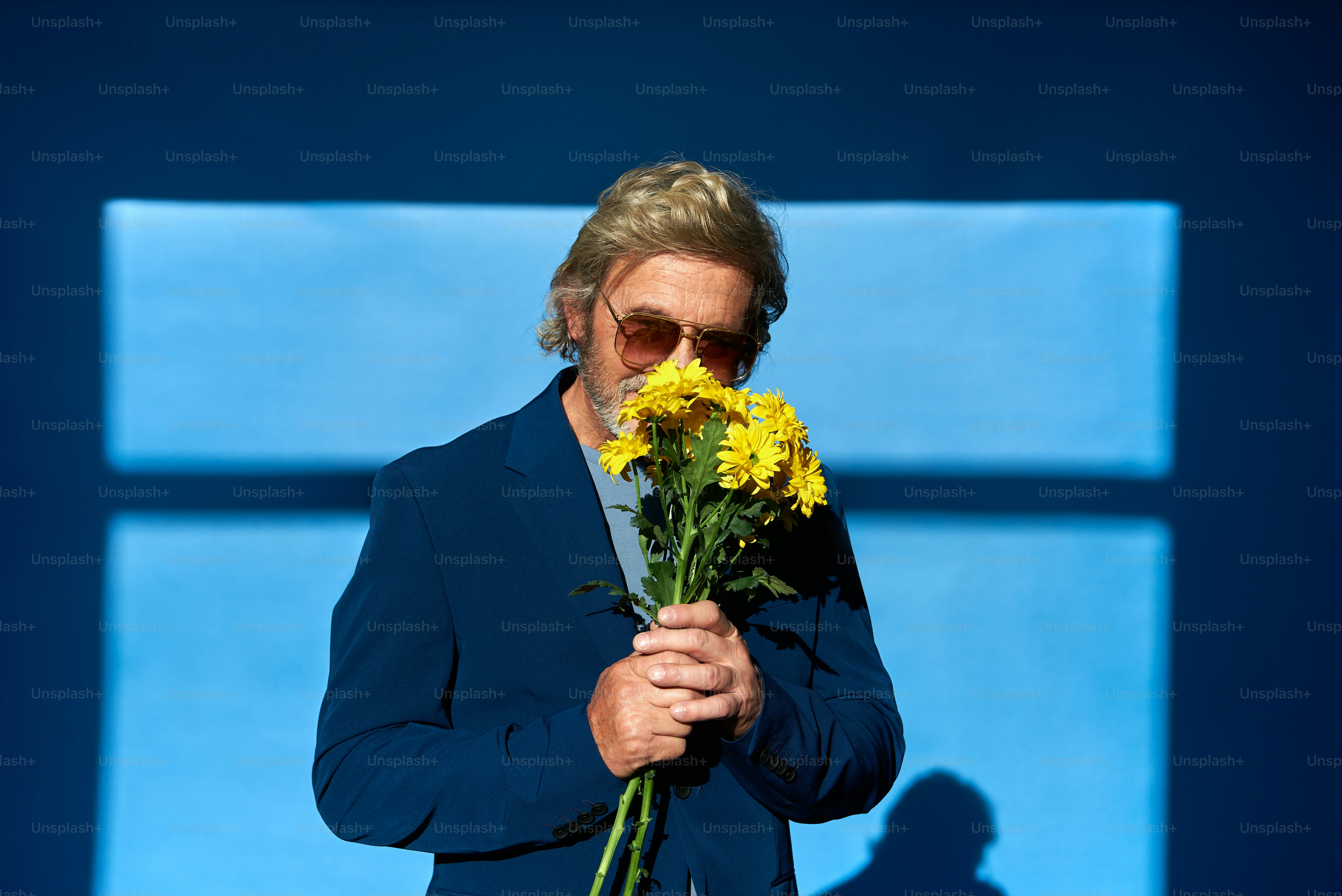 a man holding a bunch of yellow flowers