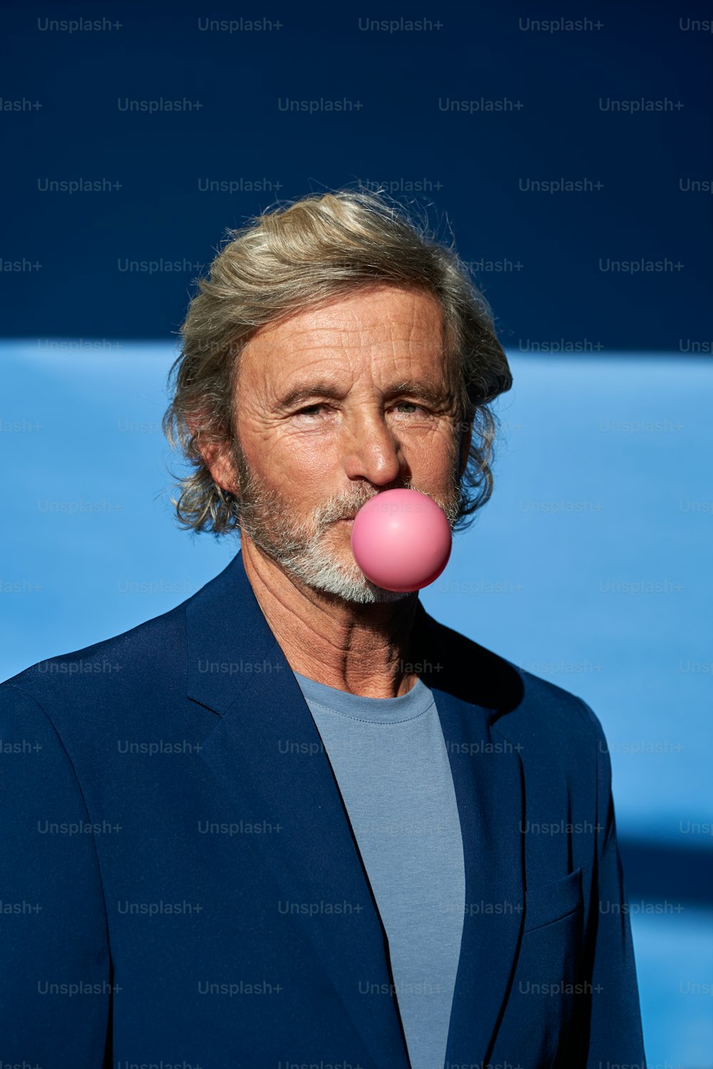 Un uomo con una bolla rosa in bocca