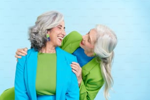 two older women hugging each other and smiling