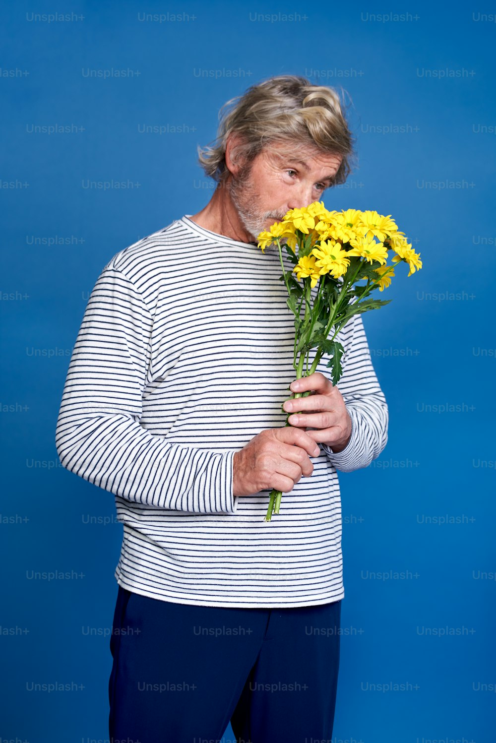 a man holding a bunch of yellow flowers