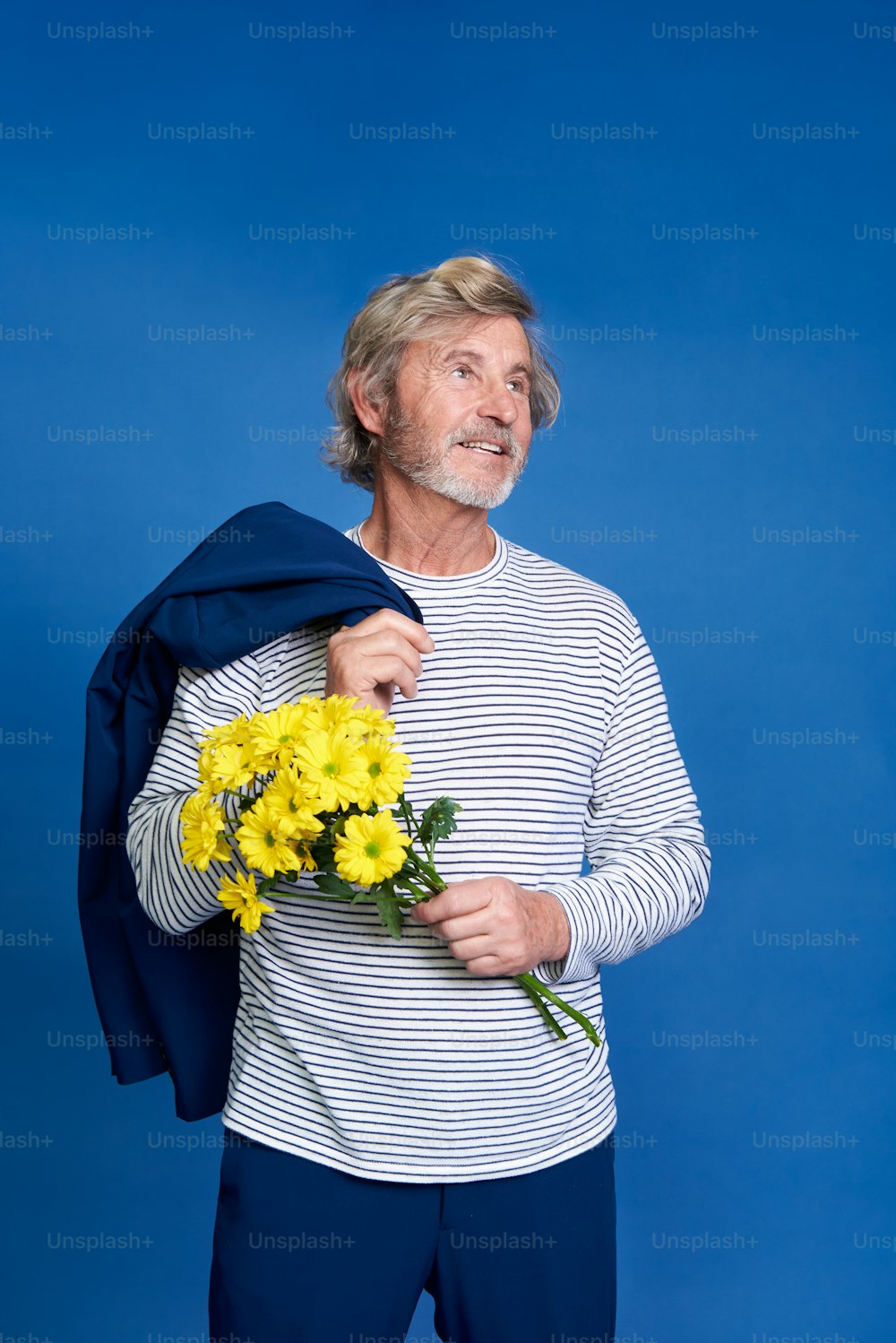 um homem segurando um buquê de flores amarelas