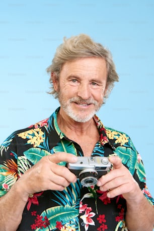 a man in a hawaiian shirt holding a camera