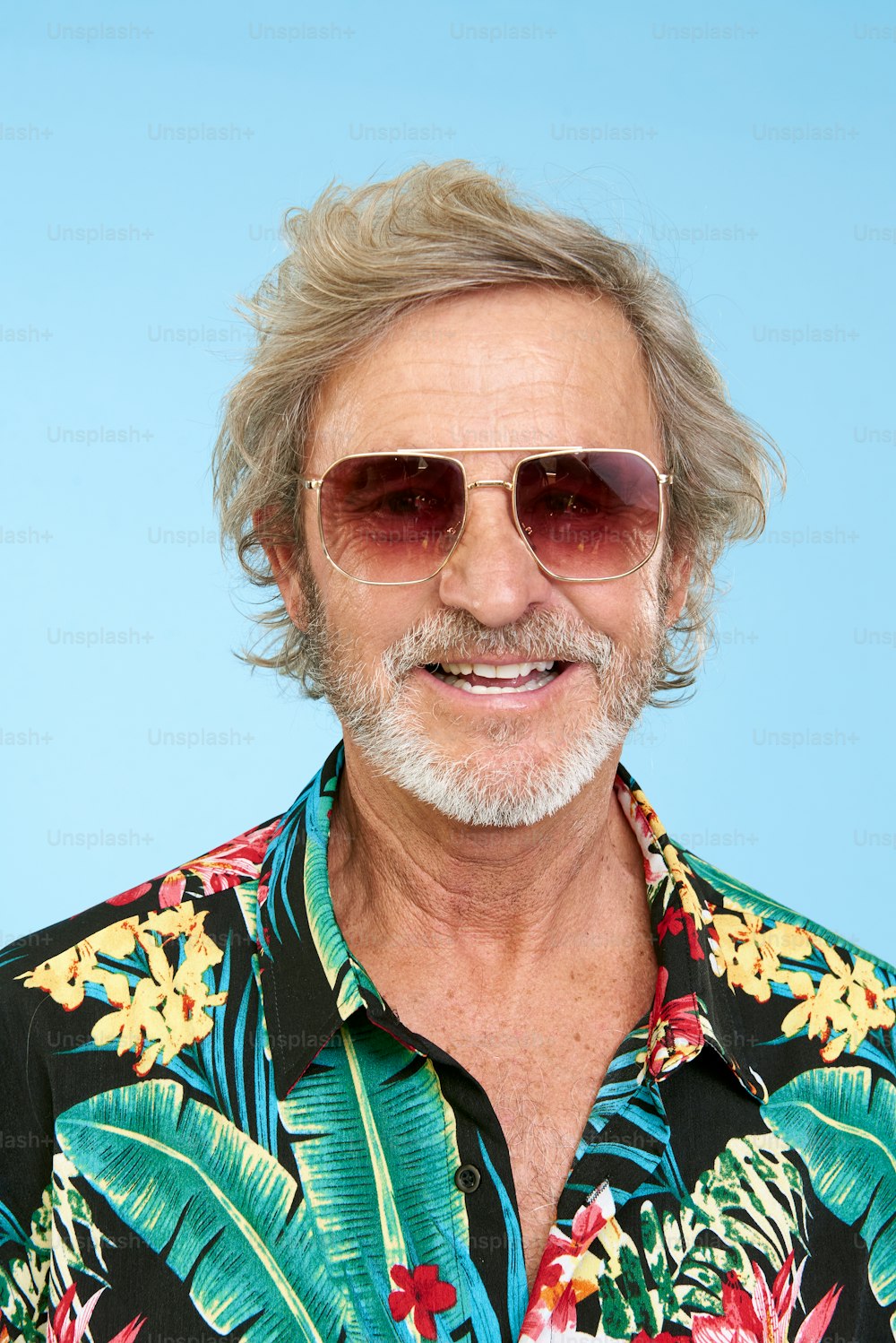 a man wearing a hawaiian shirt and sunglasses