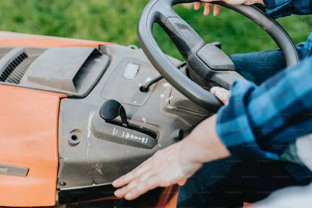 a close up of a person driving a lawn mower