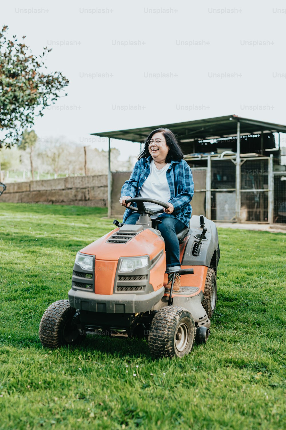 a woman riding on the back of a lawn mower