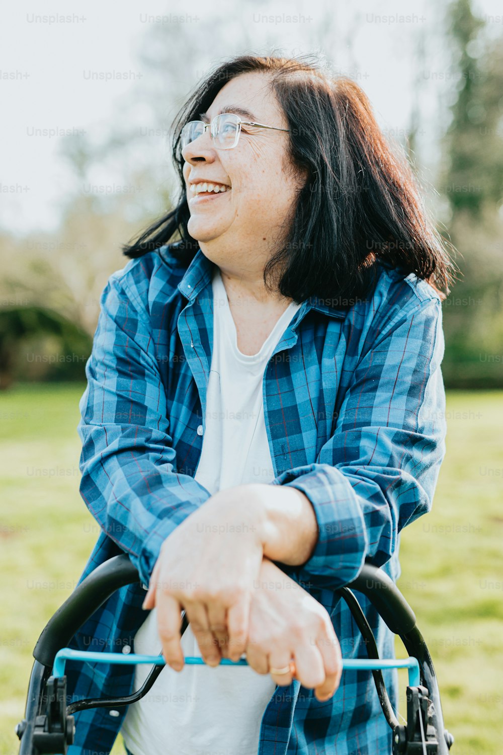 uma mulher sentada em uma cadeira de rodas em um parque