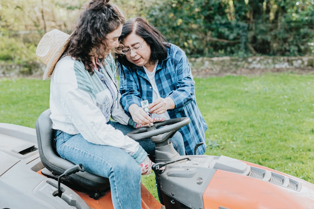 a couple of women sitting on top of a tractor