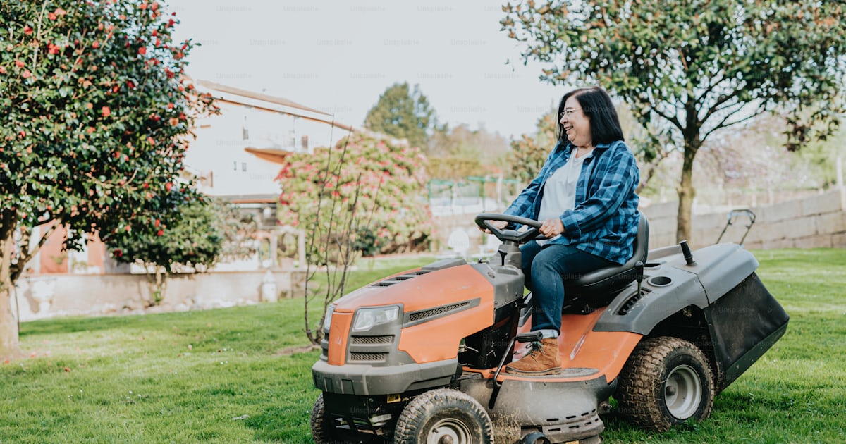A woman riding on the back of a lawn mower photo – Mower Image on Unsplash