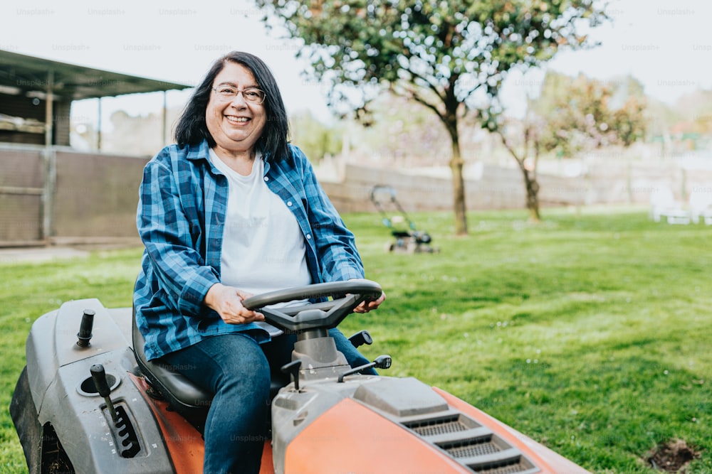 a woman sitting on top of a lawn mower