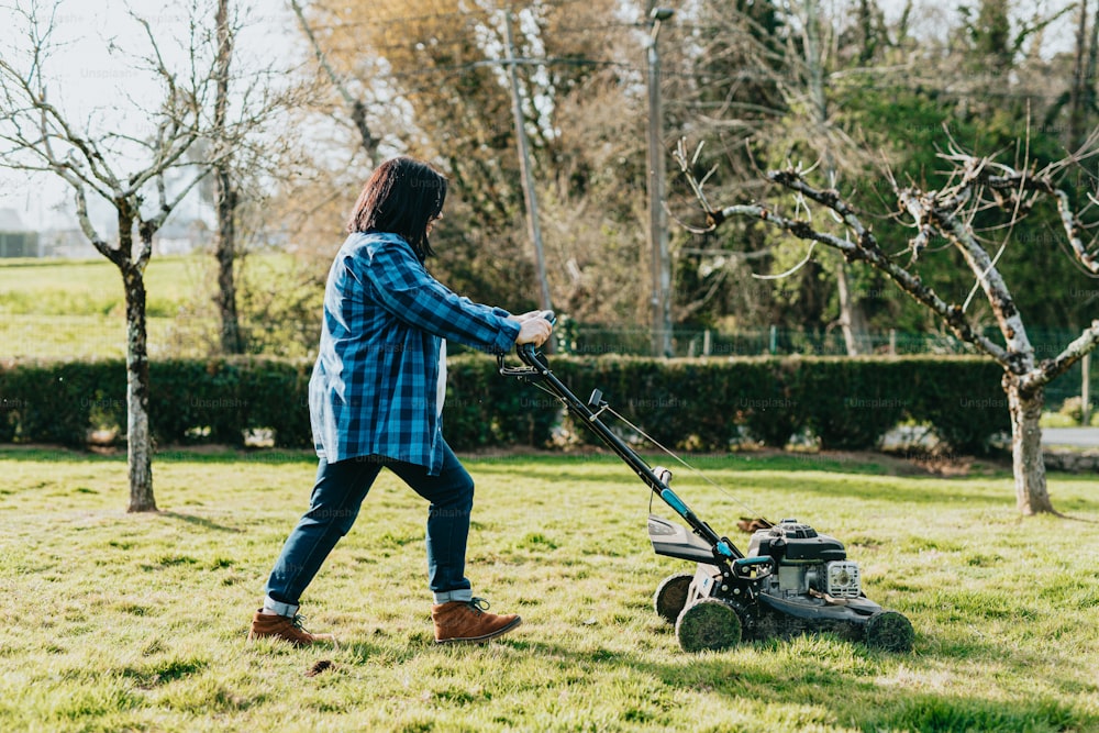 a man mowing the grass with a lawnmower