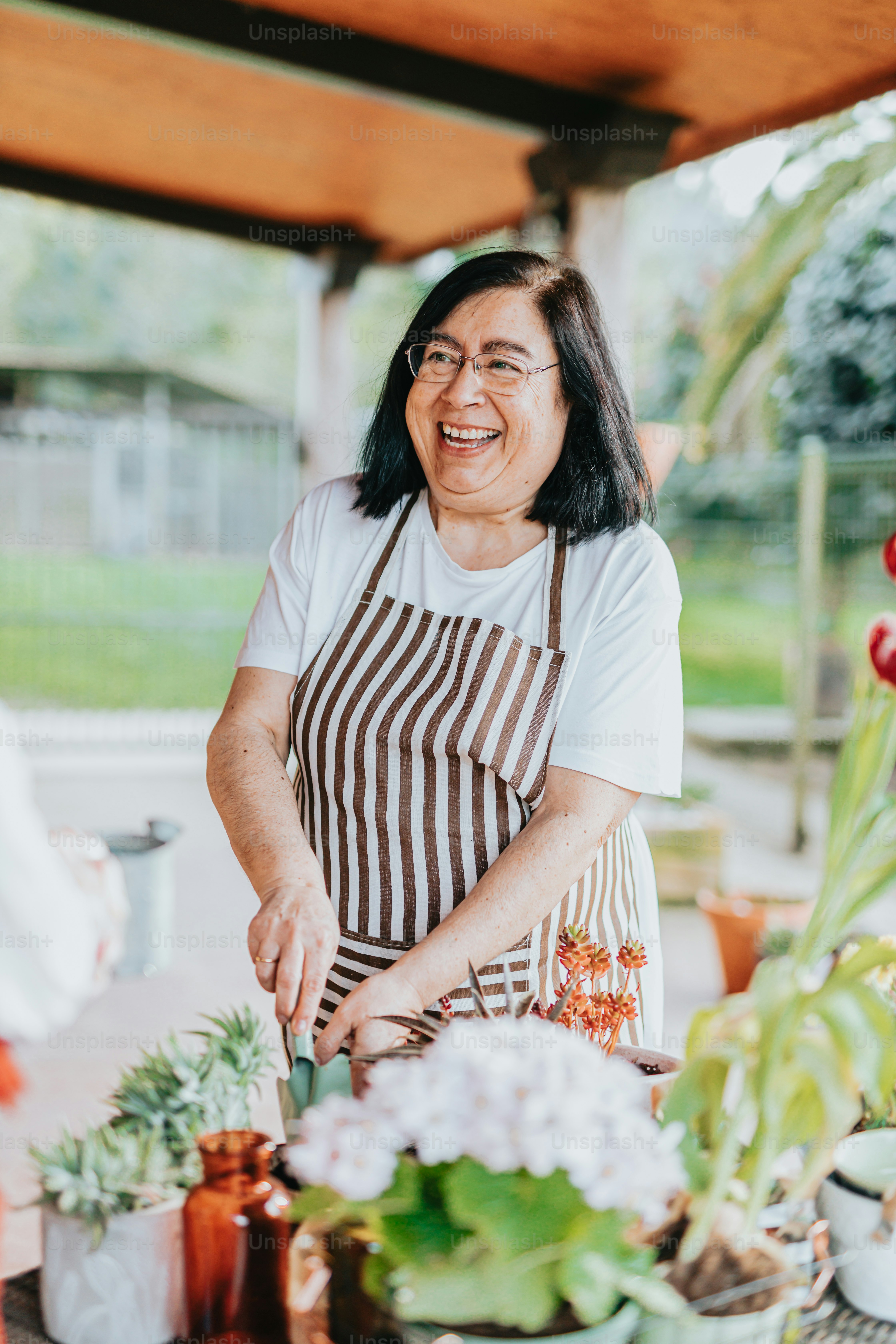 a woman in an apron is cutting up plants